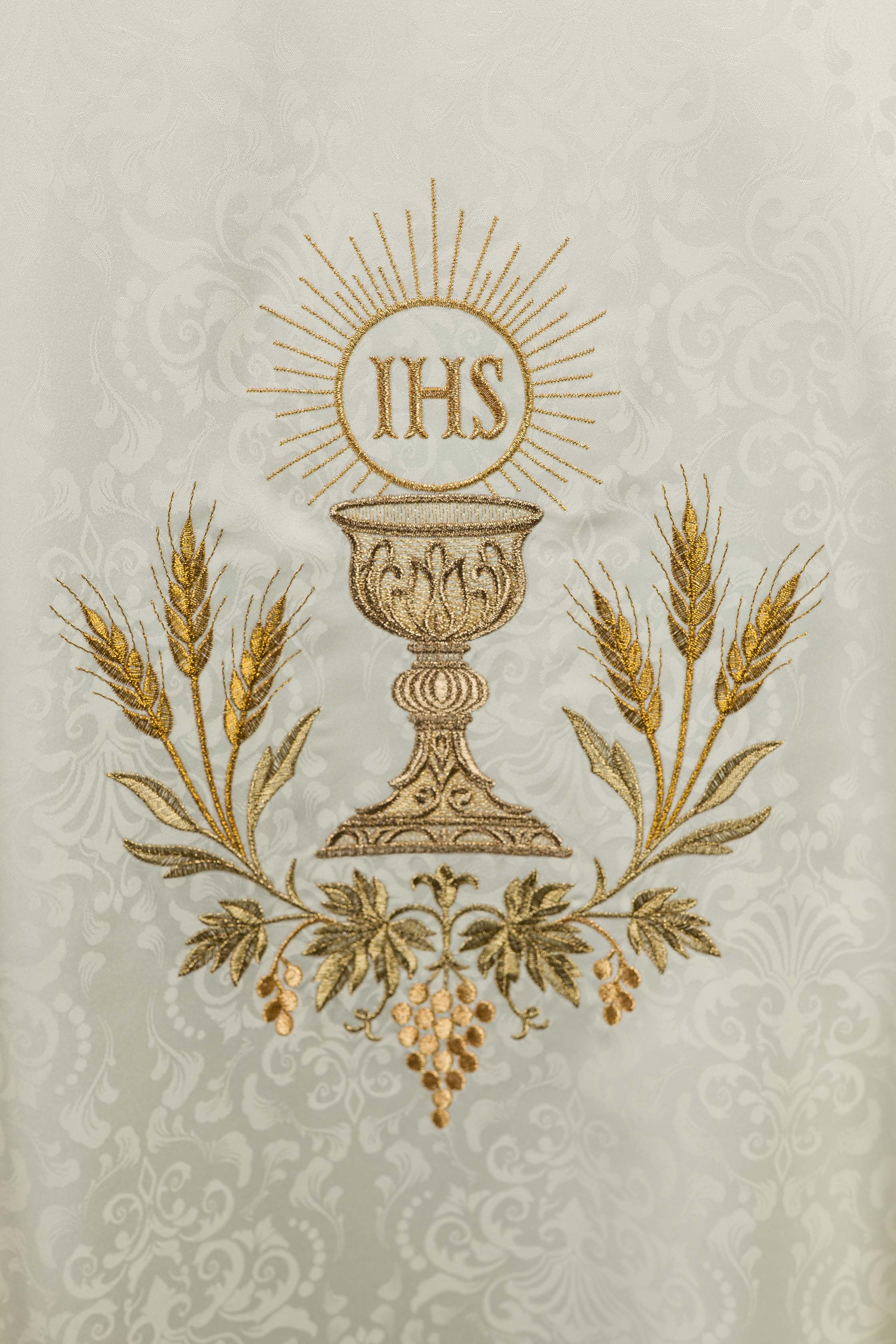 Casulla litúrgica écru con bordado de cáliz y hostia sobre tela jacquard