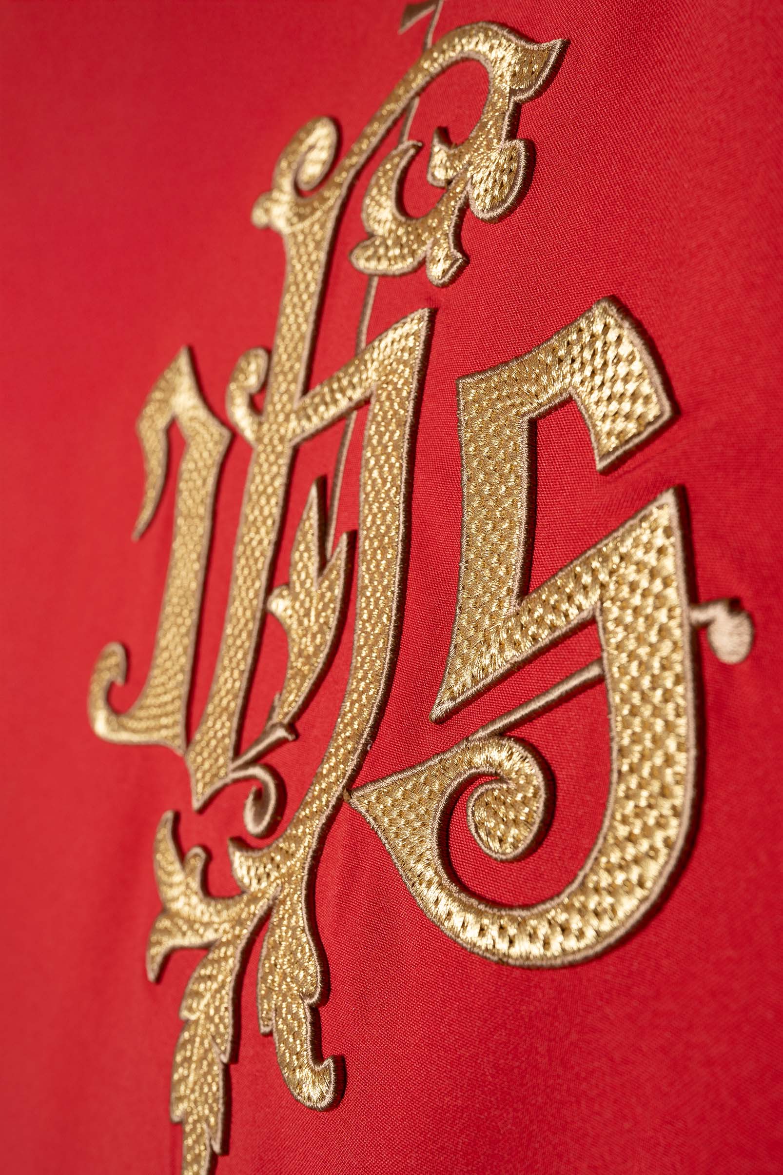 Casulla roja con bordado dorado del símbolo IHS