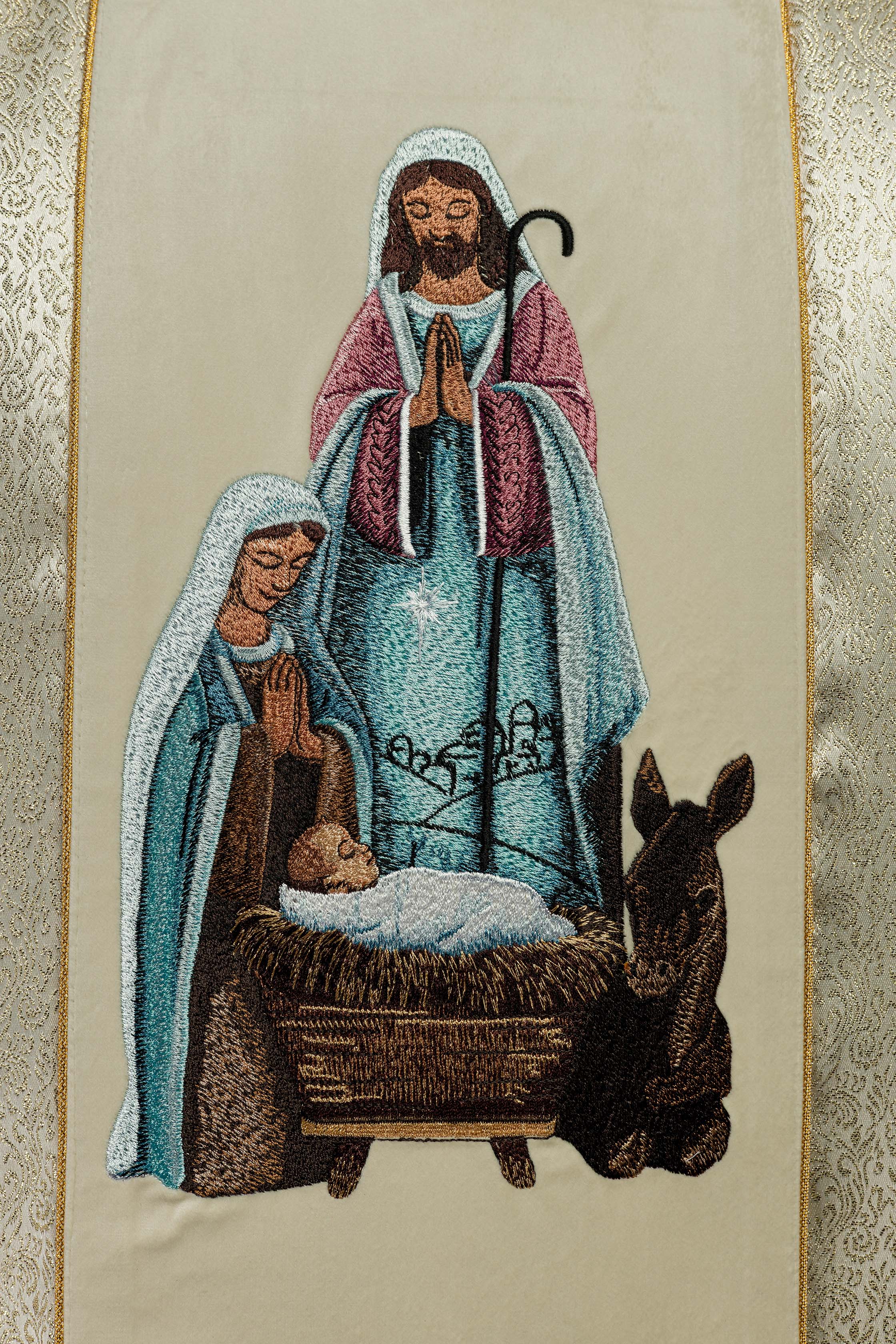 Casulla bordada con la imagen de la Sagrada Familia sobre tela dorada