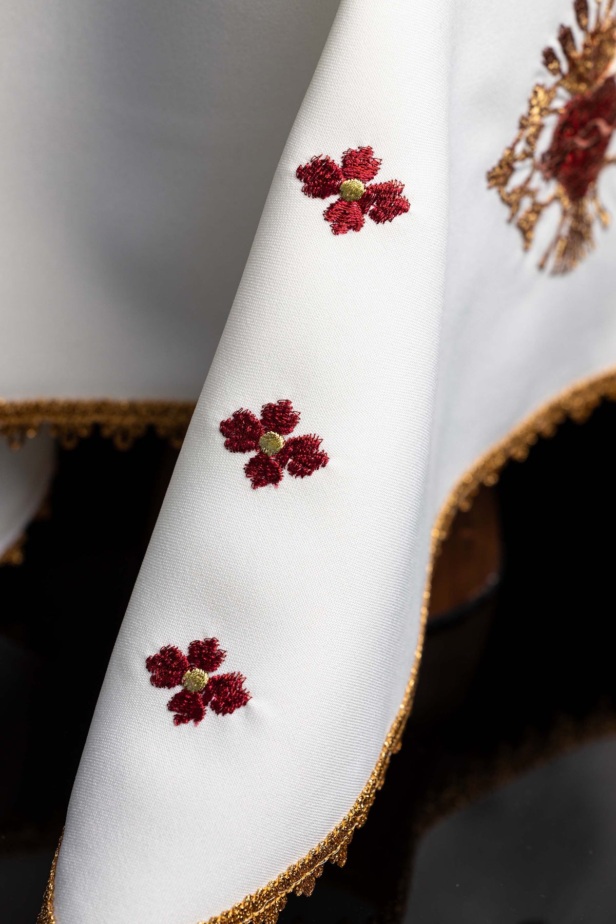 Velo para cáliz, detalle de flores rojas bordadas sobre tejido blanco