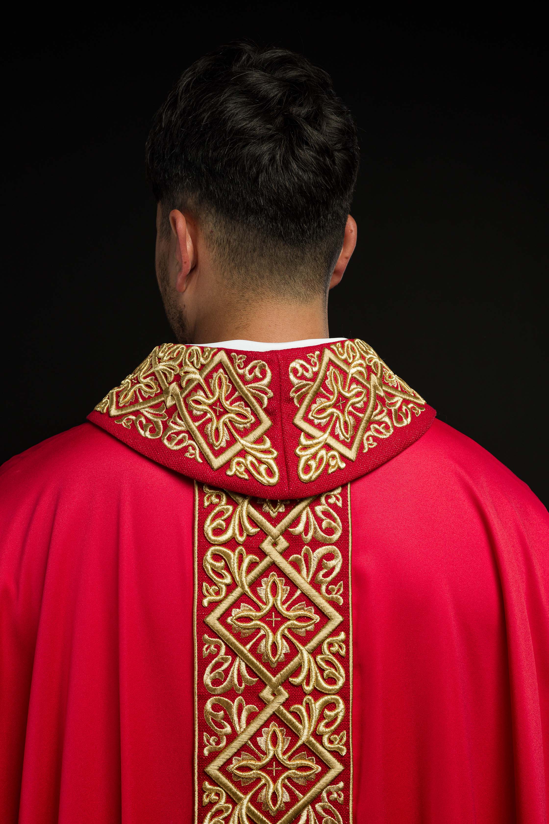 Casulla roja ricamente bordada con motivo floral y cruces