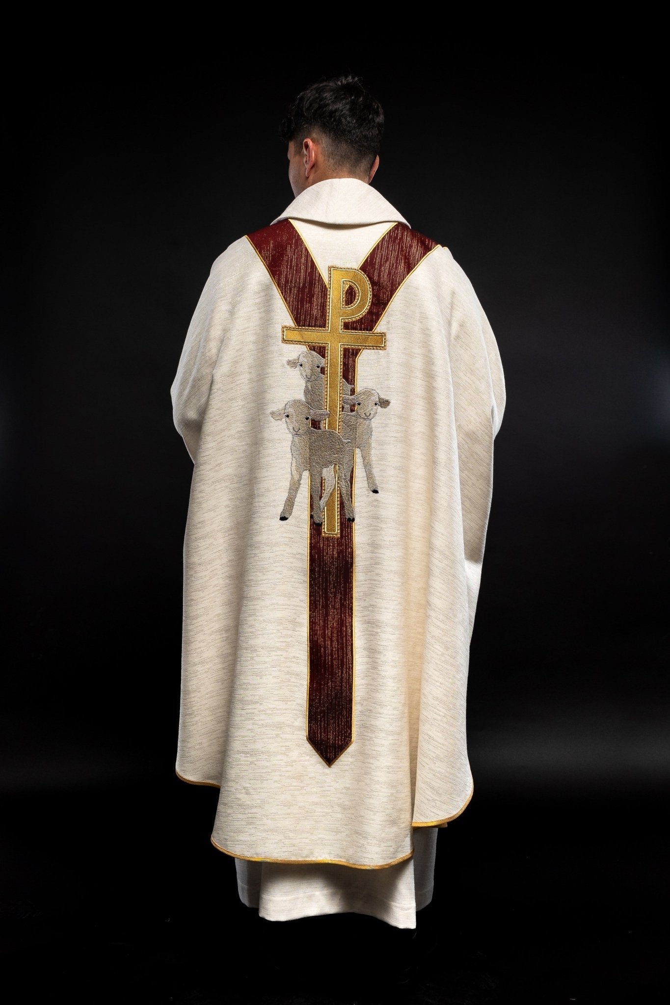 Casulla de color crudo con la imagen de Jesús Buen Pastor con una franja decorativa de color burdeos. LE/7035/05 - CASULLAS.ES