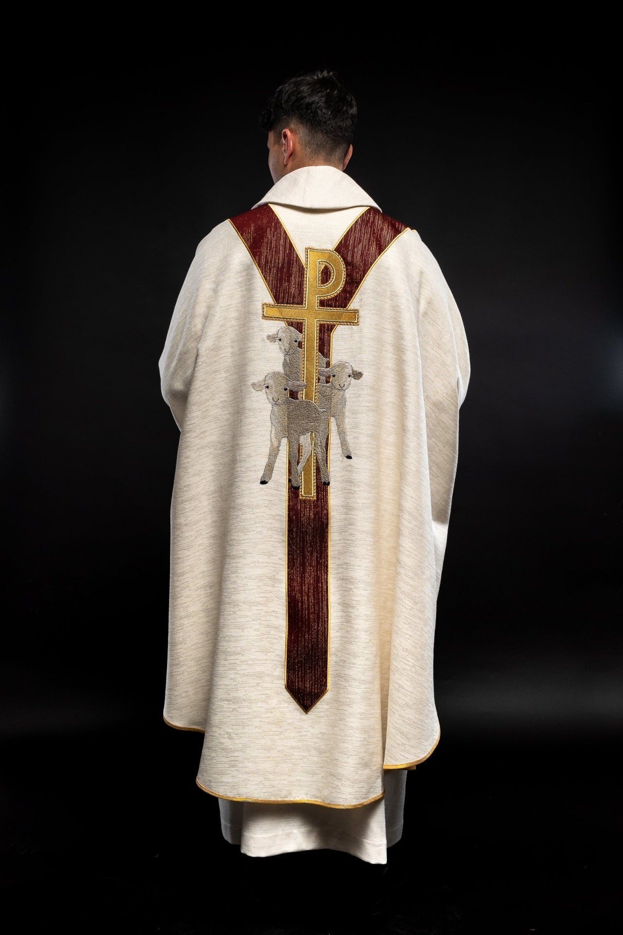 Casulla de color crudo con la imagen de Jesús Buen Pastor con una franja decorativa de color burdeos. LE/7035/05 - CASULLAS.ES