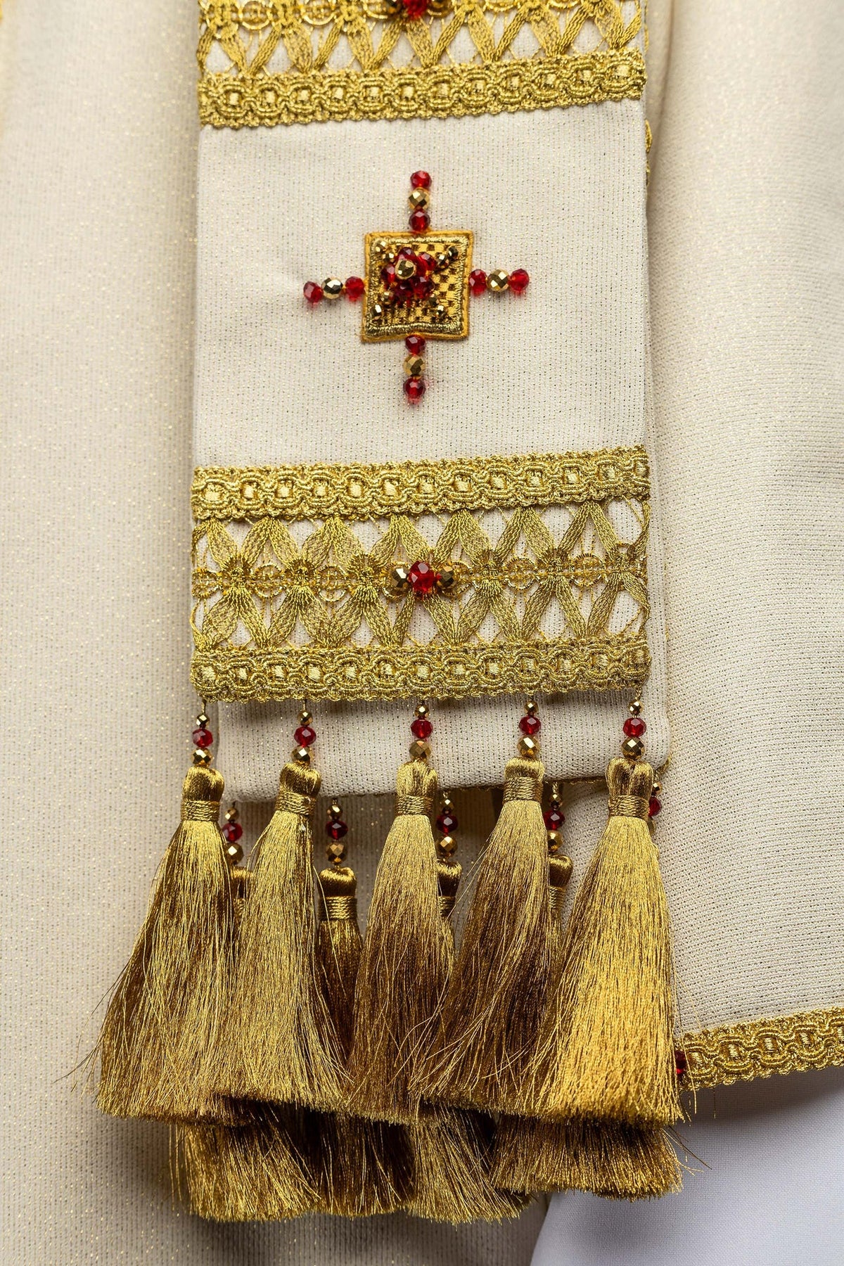 Casulla con detalle de cruz de piedras rojas, bordado dorado y borlas
