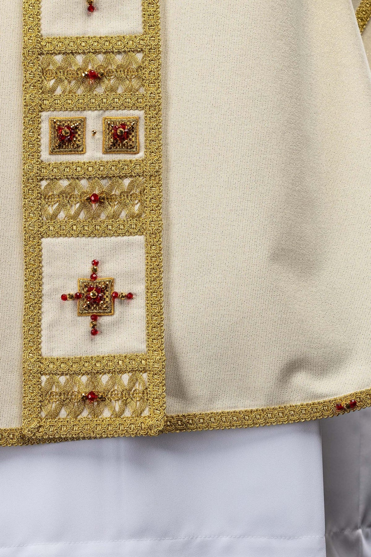 Casulla con manga marfil rematada con galón dorado y piedras rojas