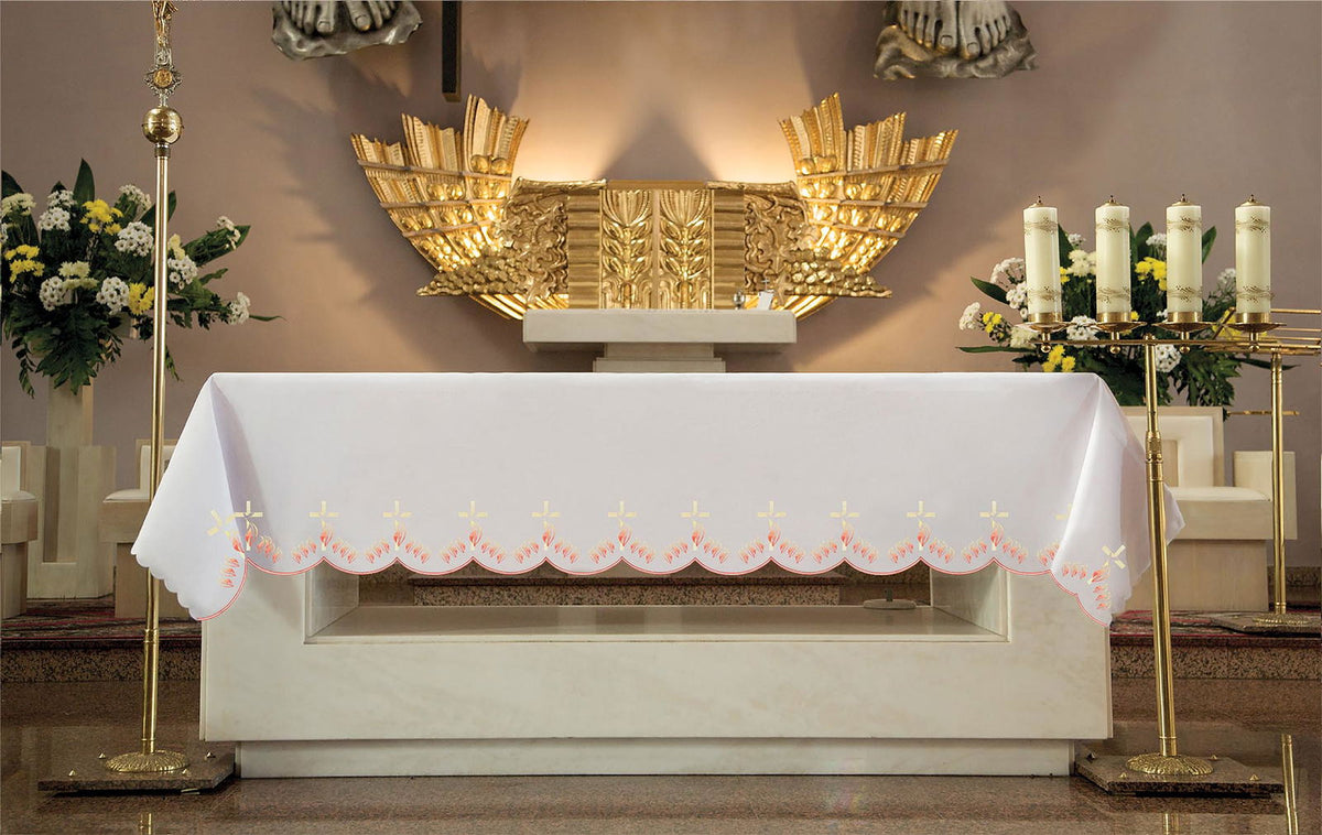 Mantel de altar con bordado frontal de cruces y llamas, blanco, visto de frente sobre el altar