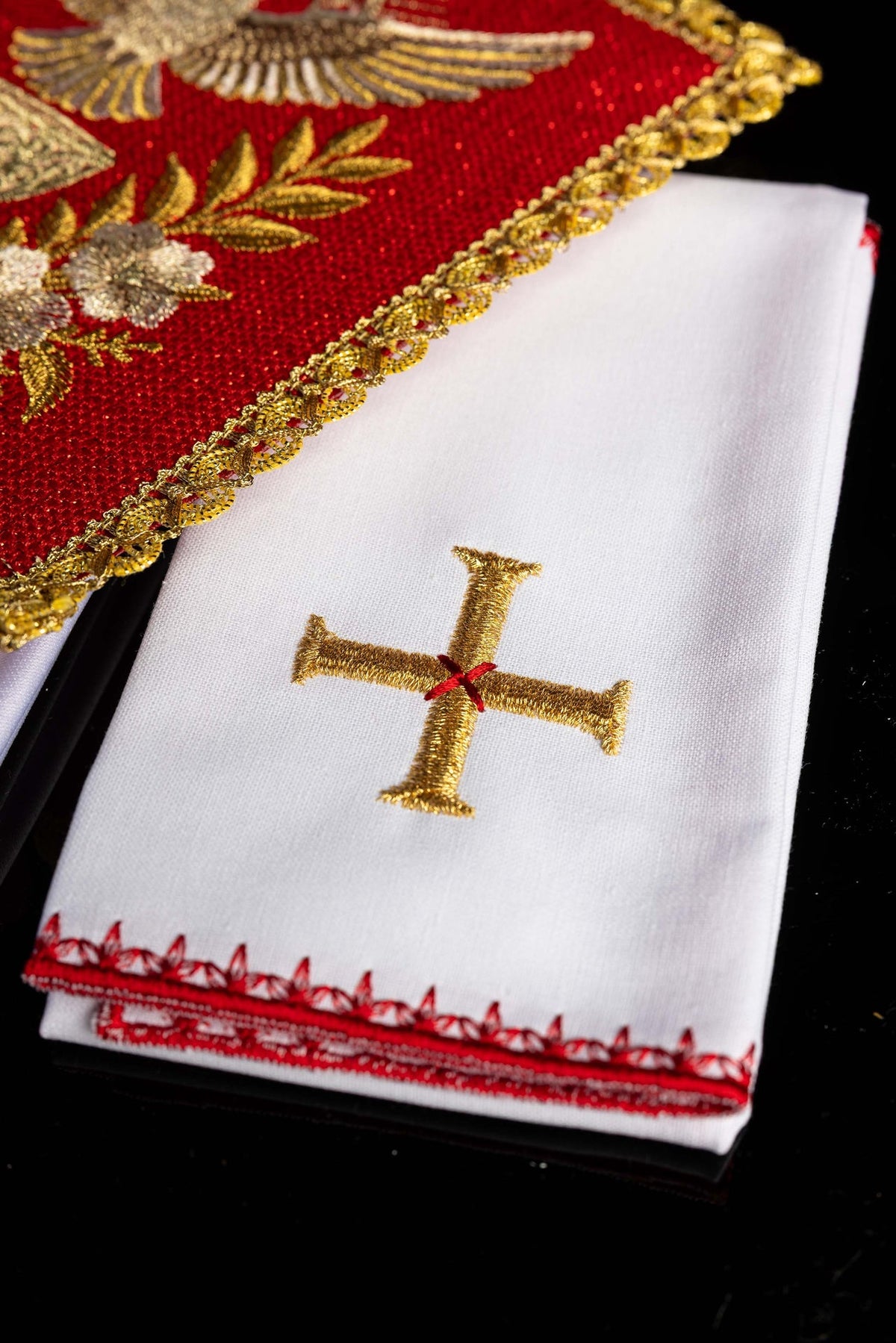Juego de altar rojo bordado, detalle de cruz dorada y cenefa roja sobre pieza blanca