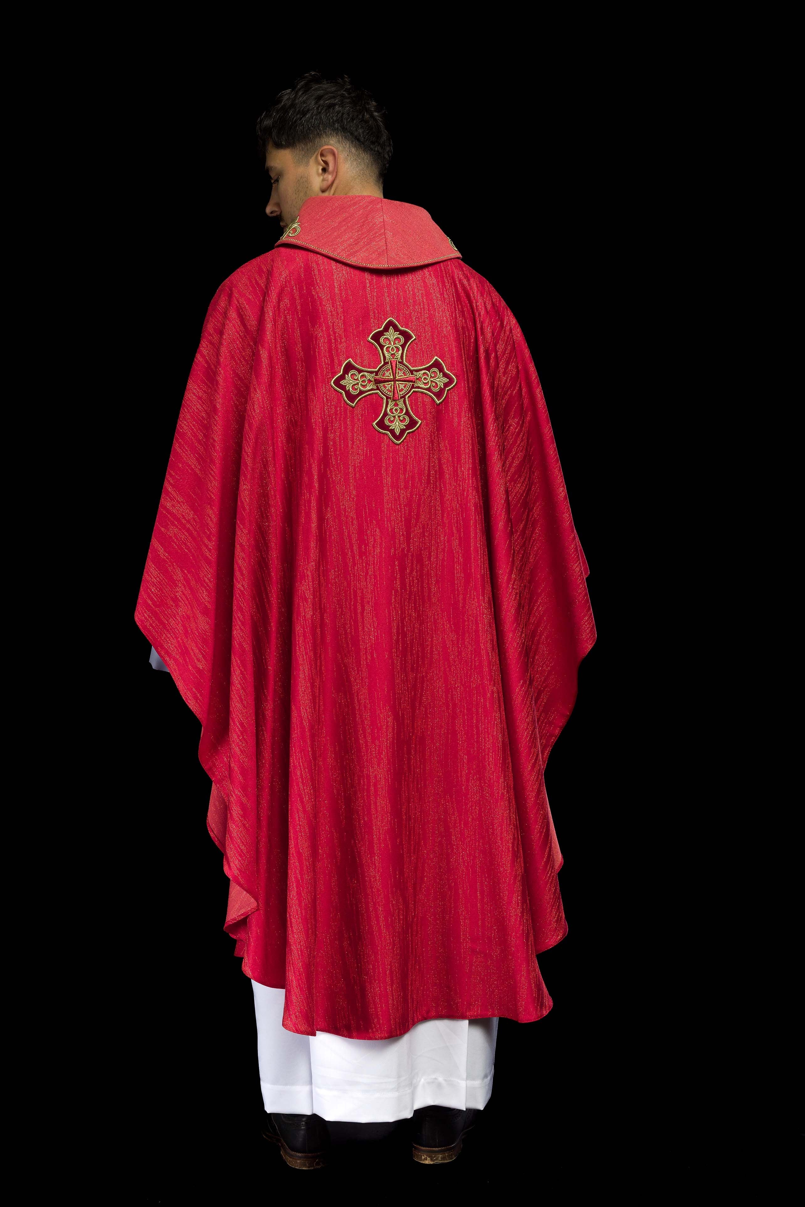 Casulla roja con motivo bordado de cruz sobre tejido decorativo