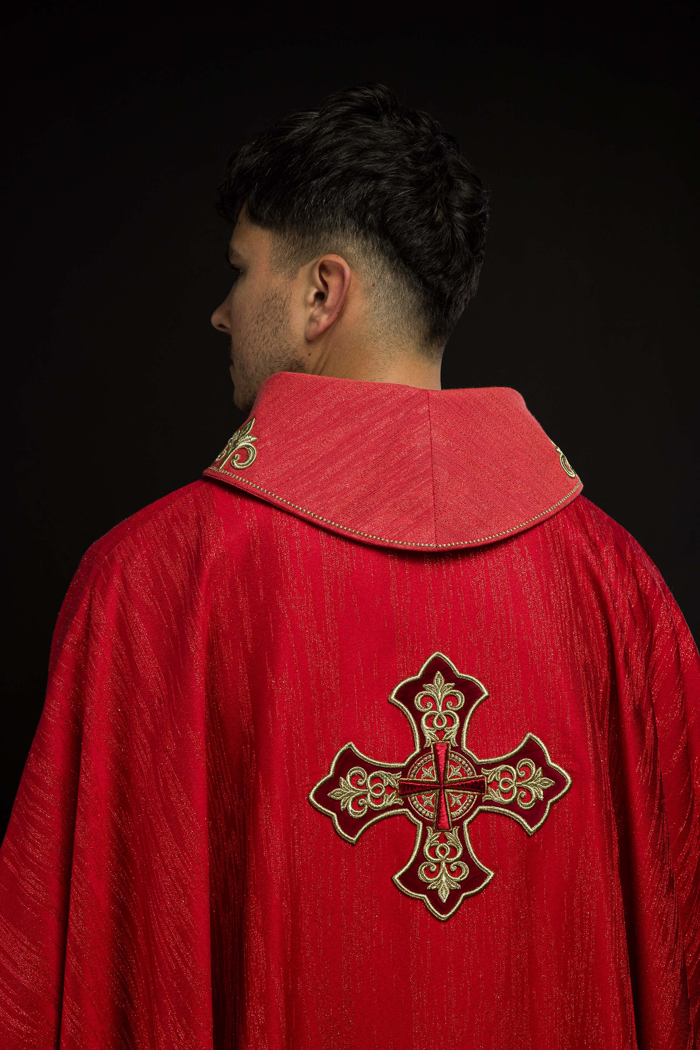 Casulla roja con motivo bordado de cruz sobre tejido decorativo