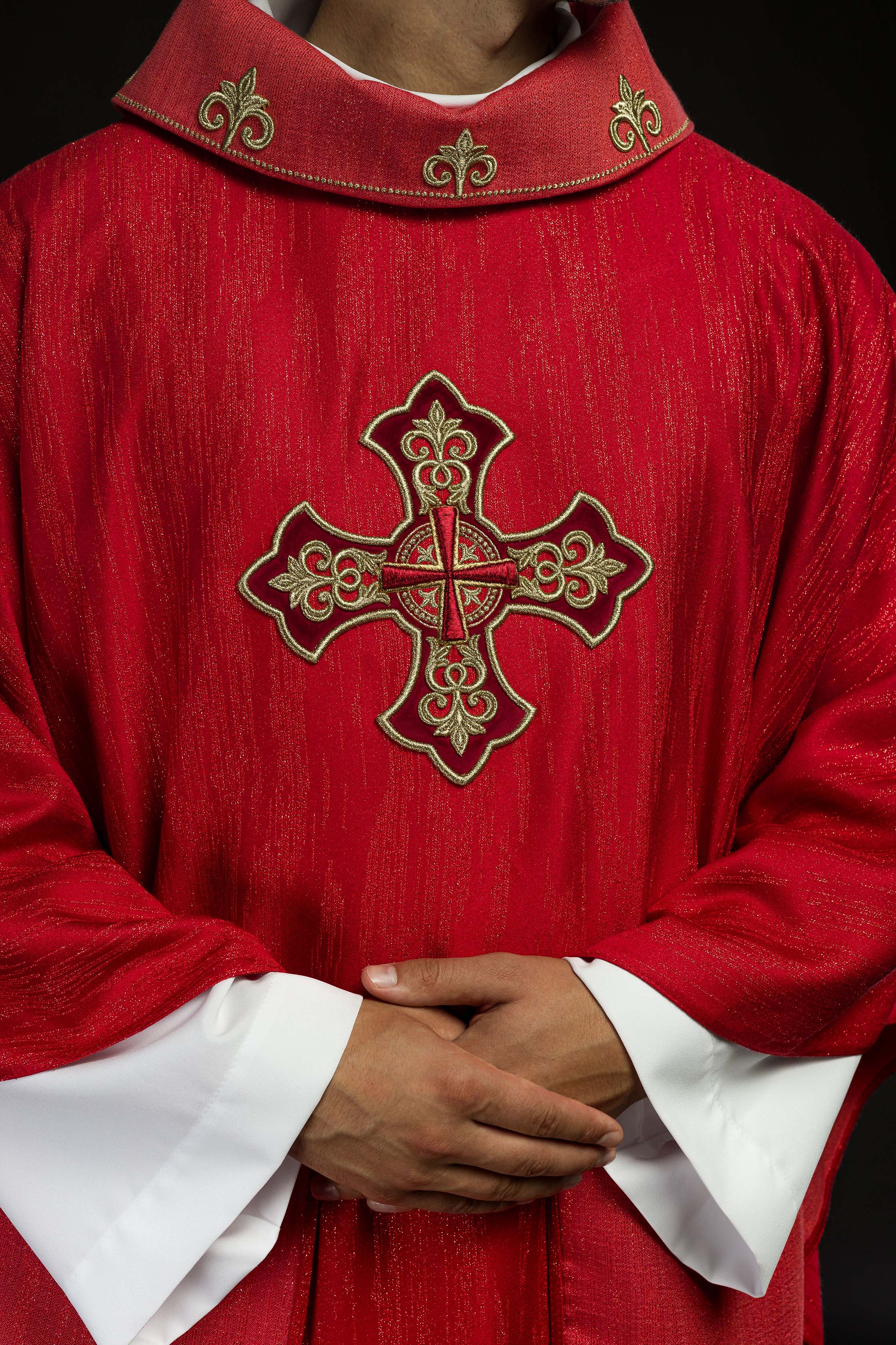 Casulla roja con motivo bordado de cruz sobre tejido decorativo