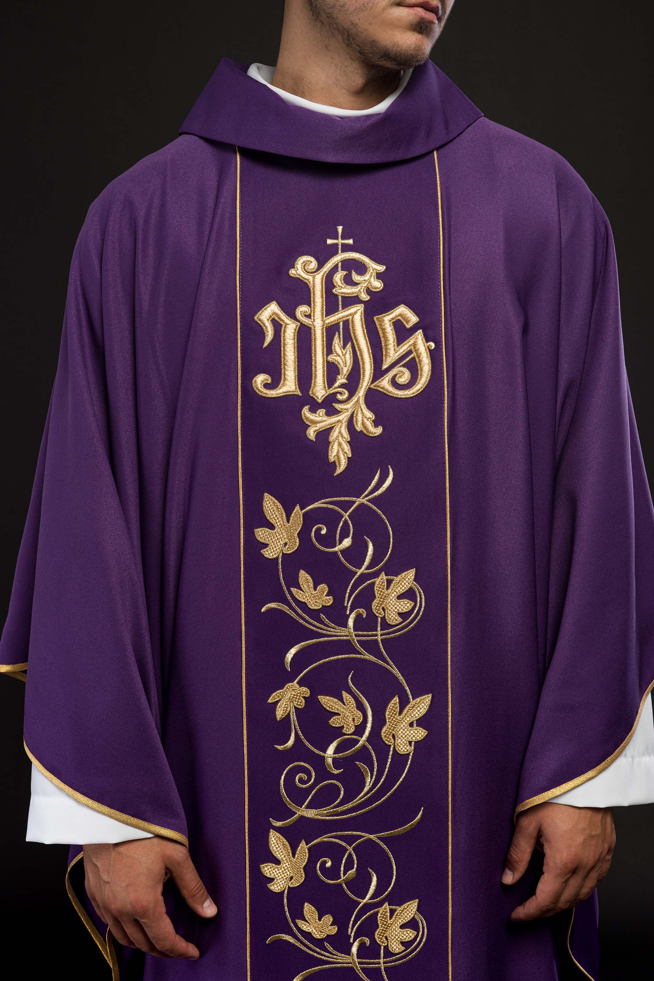 Casulla litúrgica morada con cinturón ricamente decorado con motivos florales e IHS