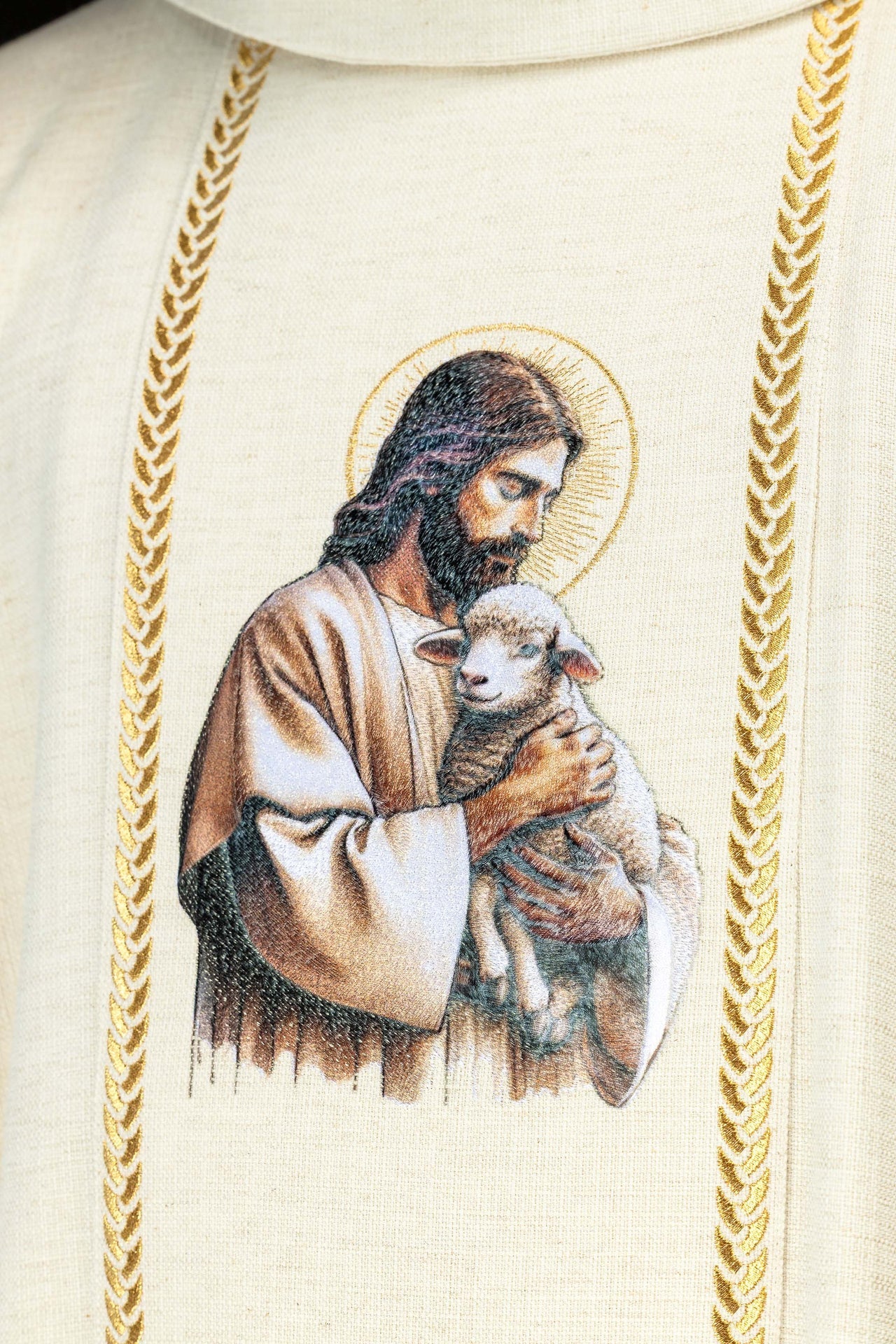 Casulla bordada con bandas y la imagen de Jesús Buen Pastor con un cordero en color crudo KOW2/022/05/49 - CASULLAS.ES