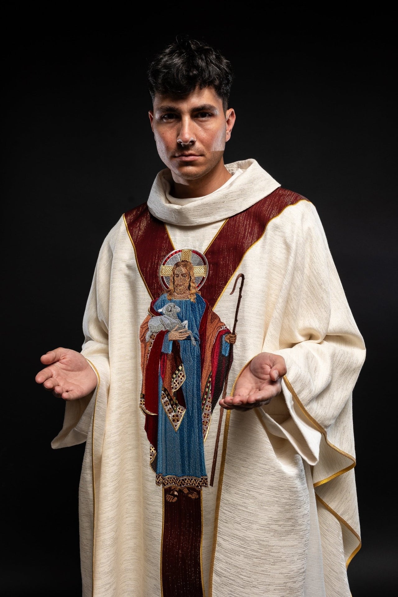 Casulla de color crudo con la imagen de Jesús Buen Pastor con una franja decorativa de color burdeos. LE/7035/05 - CASULLAS.ES