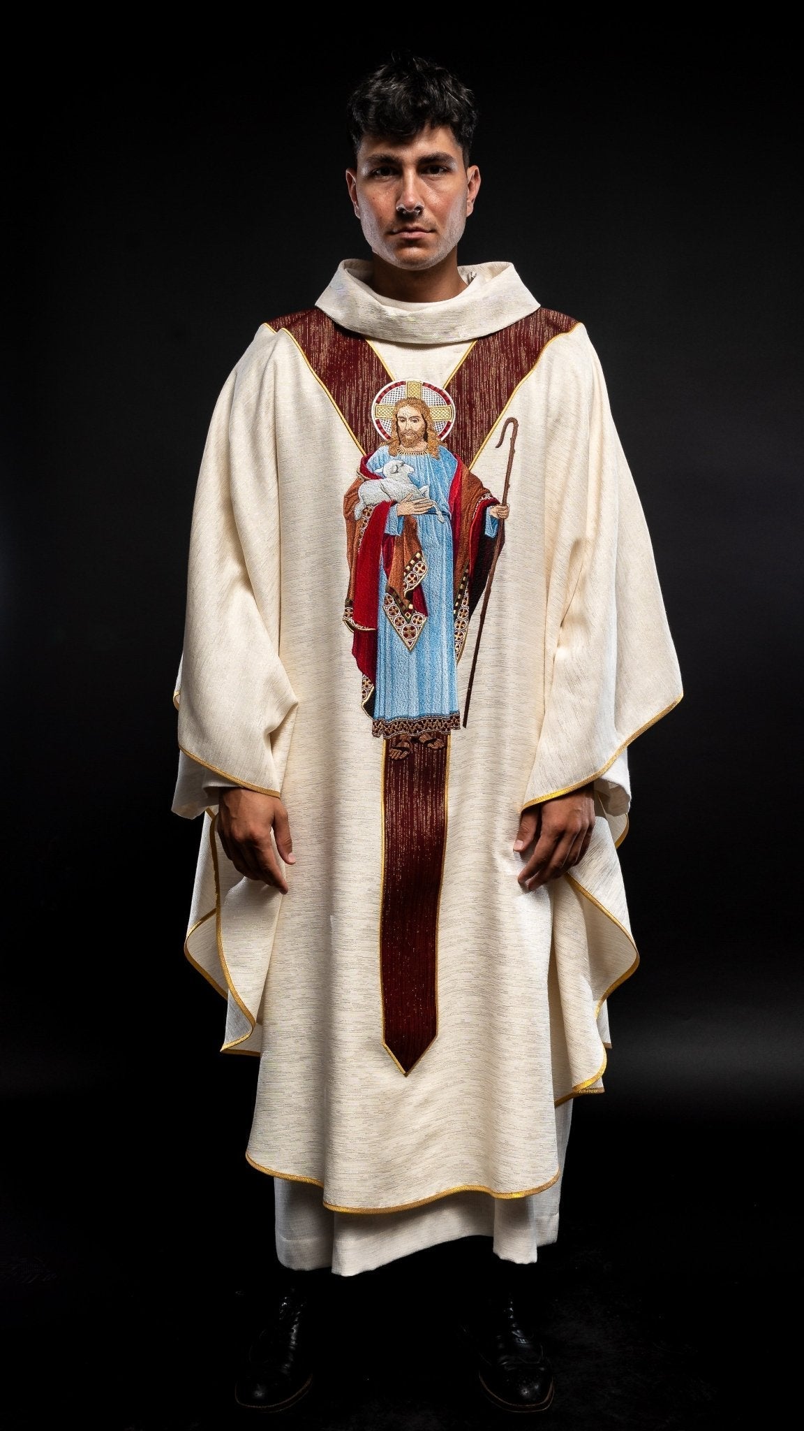 Casulla de color crudo con la imagen de Jesús Buen Pastor con una franja decorativa de color burdeos. LE/7035/05 - CASULLAS.ES