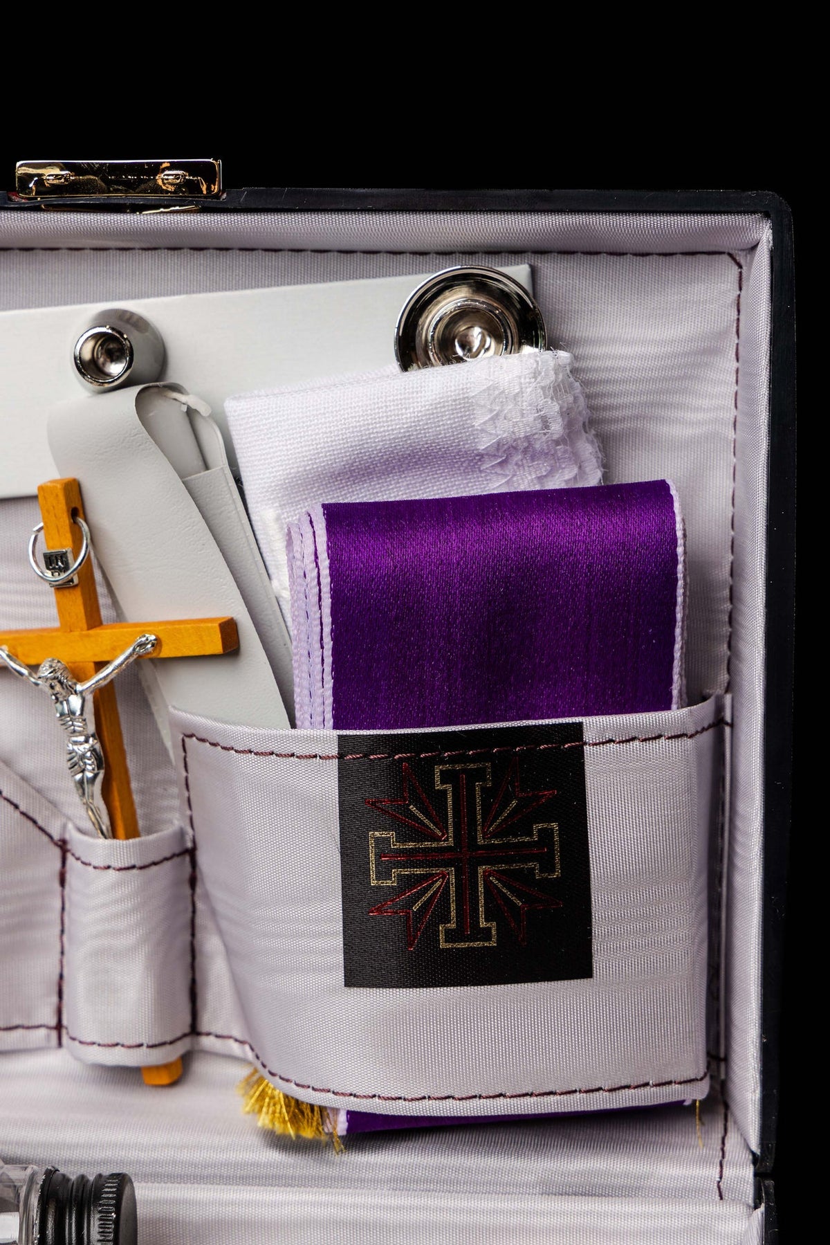 Detalle de maleta litúrgica con paño morado y cruz bordada