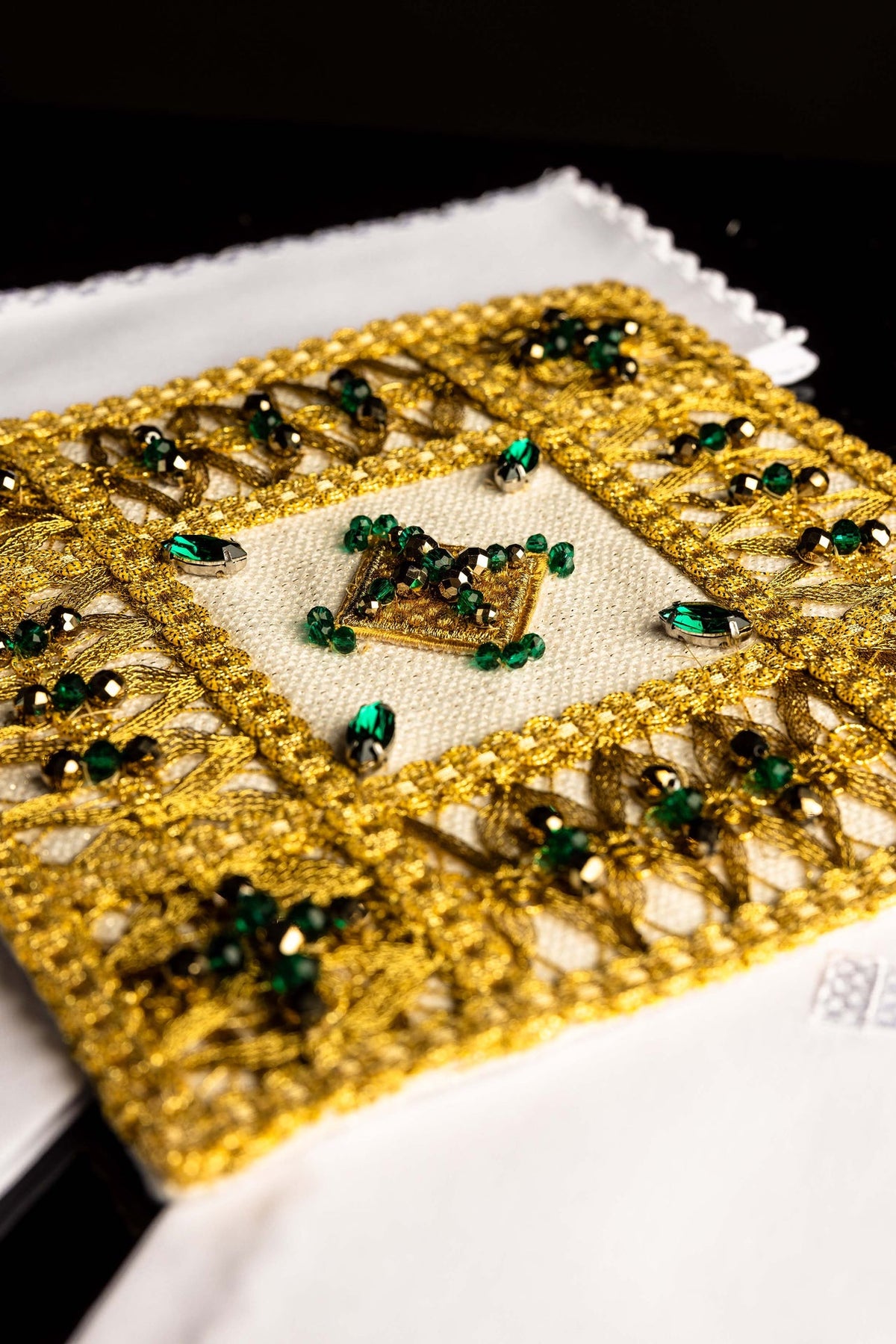 Juego de altar en primer plano, detalle del bordado dorado y piedras verdes