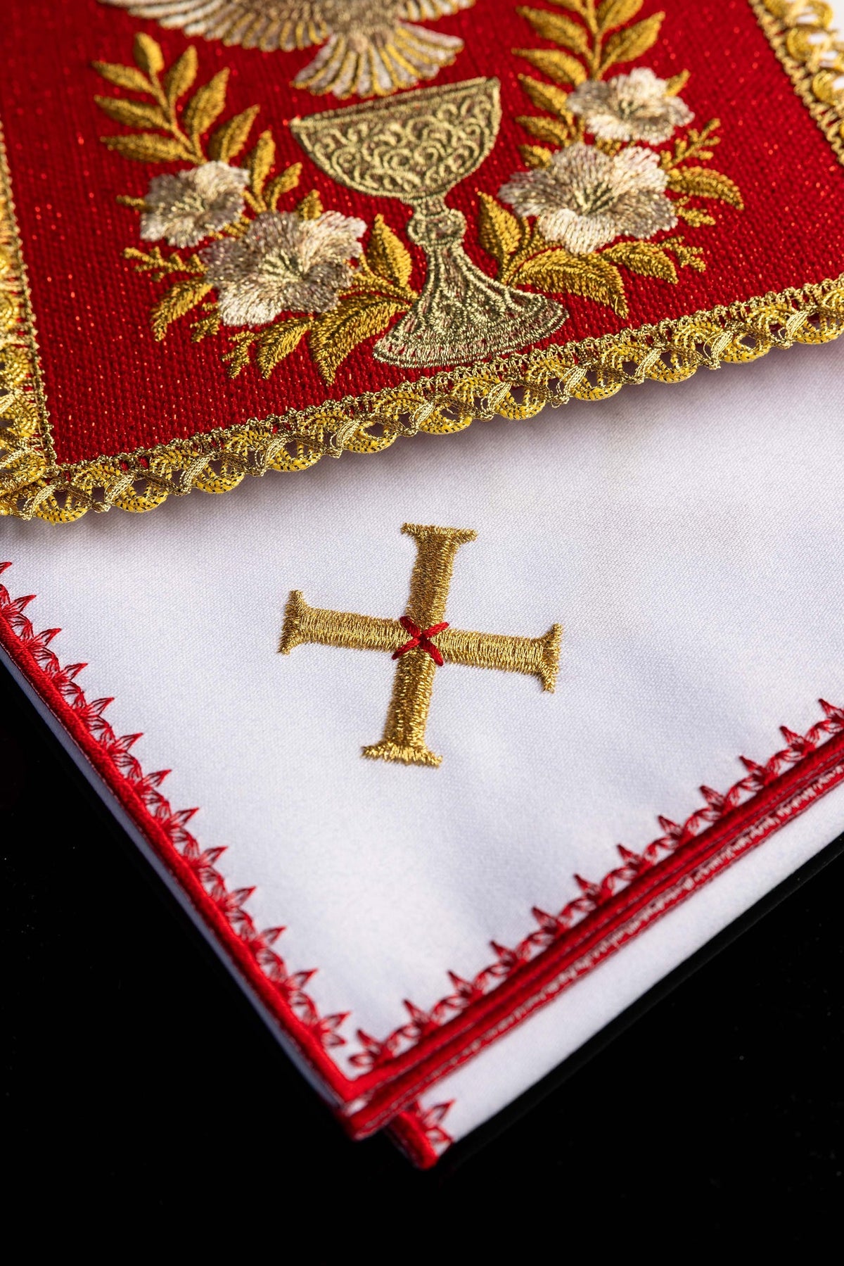 Juego de altar rojo bordado, detalle de cruz dorada sobre pieza blanca con ribete rojo